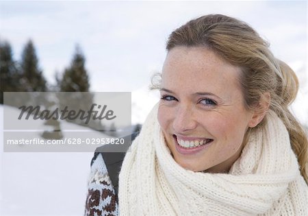 Happy woman wearing scarf in winter landscape