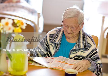 Senior woman reading magazine in retirement home