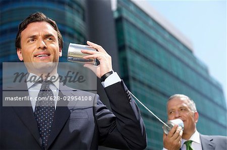 Deux hommes d'affaires avec un téléphone de boîtes de conserve