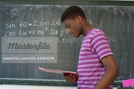 Schüler lesen, Tafel mit Formel im Hintergrund