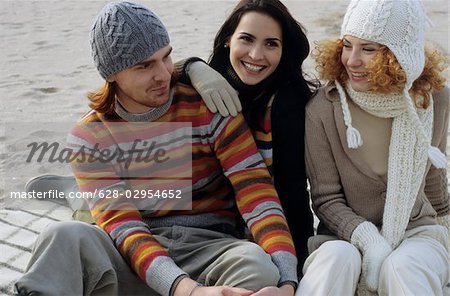 Three Friends in warm Clothing at the Beach - Friendship - Trip - Beach - Season