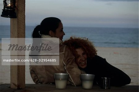 Redhaired Woman leaning against a Friend - Coldness - Friendship - Beach - Season