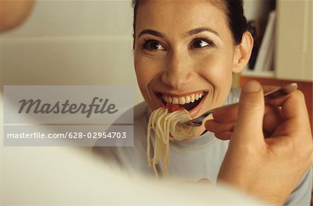 Man feeding his Girlfriend with a forkfull of Spaghetti - Love - Cooking - Dinner