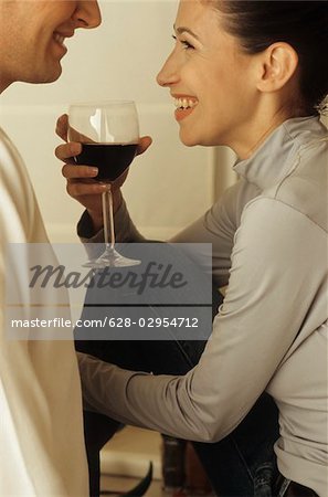 Homme debout devant une femme avec un verre de vin dans sa main - alcool - convivialité