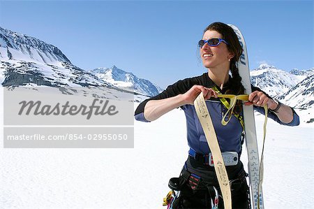 Woman Climber Attaches Climbing Skins to Skis AK SC Spring Chugach Mtns
