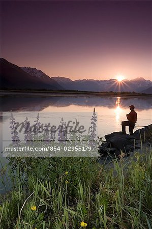 Hiker along 20-mile River @ sunrise stops near Lupine to view scenery Chugach National Forest AK Summer