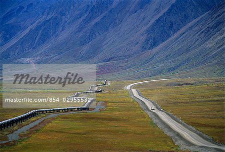 Fahrzeug fährt auf dem Dalton Highway neben der Trans-Alaska-Pipeline in Alaska, Arktis im Sommer.
