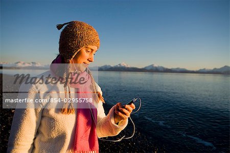 Woman listens to iPod at Bishops Beach at Kachemak Bay in Homer, Alaska