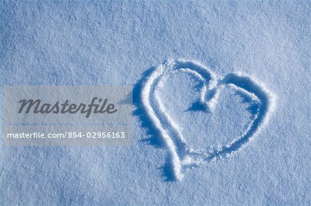 Drawing of heart in blanket of fresh snow winter Alaska