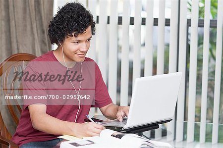 Teenager Doing Homework and Using Laptop Computer