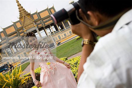 Man taking picture young woman front of Royal Palace,Phnom Penh,Cambodia