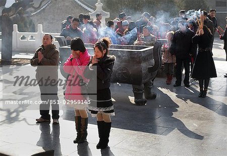 Fashionably dressed Buddhist women making incense offerings at the Da Ci'en Temple,Xian,Xi'an,Capital of Shaanxi Province,China
