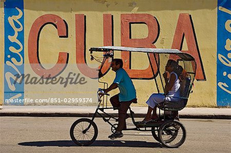 Un Ricksaw passe un signe Viva Cuba, la Havane, Cuba