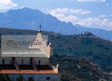 Church and mountains,Haute-Balagne view towards Pigna Porto,Corsica