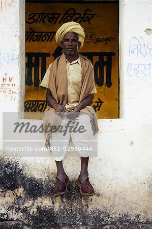 A man in clogs sitting in a window in Kumbhalgarh,Rajasthan,India