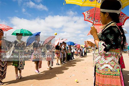 Hmong girls in traditional costume throwing tennis balls at a courting ceremony at the New Year festival,Phonsavan,Laos