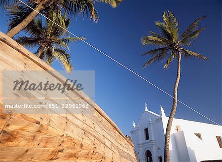 Palmiers et coque de pêche en bateau à côté de l'église de Santo Antonio, Ilha de Mocambique, Mozambique.
