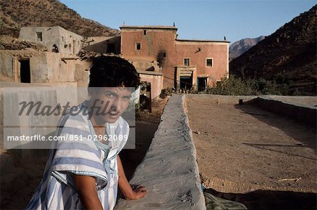 Local man robe by wall in village,Marrakesh,Morocco.