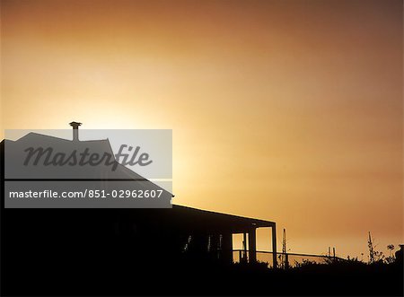 Silhouette de maison de plage au crépuscule, Kommitjie, péninsule du Cap, Afrique du Sud.