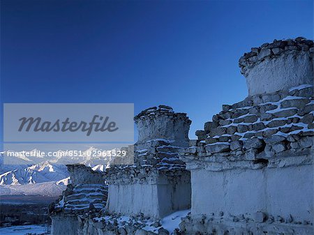 Chortens covered in snow beside Leh,looking over to Stok Kangri at dawn,Ladakh,India.
