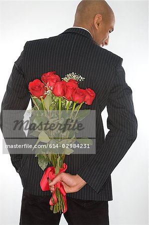 Man with a bunch of roses behind his back