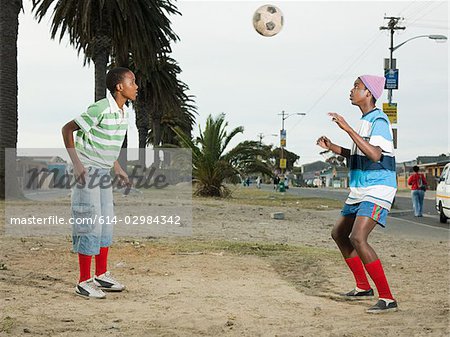 Jungs spielen Fußball in der Straße