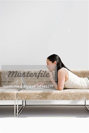 Japanese woman using laptop computer on sofa