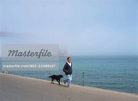 People walking with dog at Fort Point, Golden Gate Bridge, San Francisco