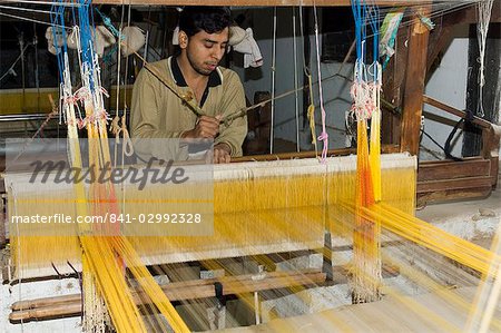 A man weaving at one of the cooperatives in an area that is famous for its saris, Maheshwar, Madhya Pradesh state, India, Asia