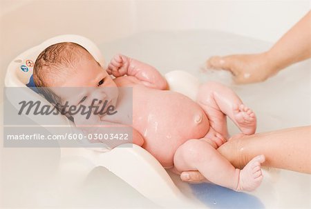 3 Week Old Baby Girl Getting a Bath - Foto de stock - Masterfile