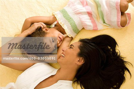 Mutter und Tochter zusammen auf dem Bett liegend