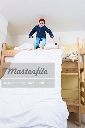 Boy with skis on bed