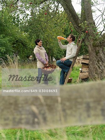 Man and woman picking apples relaxing