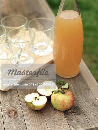 Apples,apple juice and glasses on table