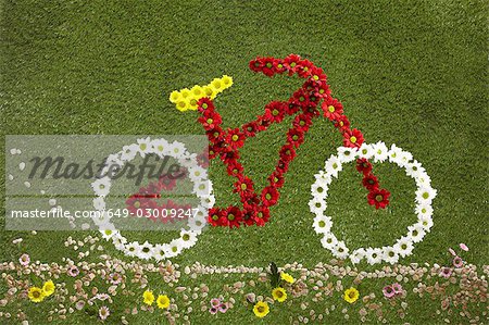 A bike made out of flowers set on grass