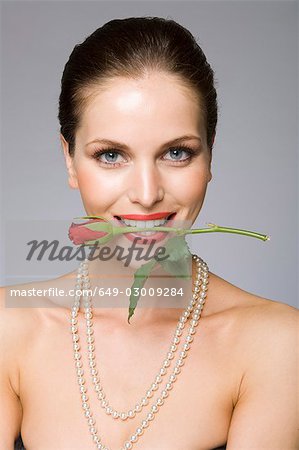 Female beauty model rose in mouth