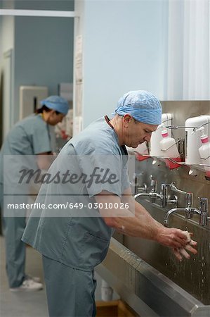 Medical staff in scrubs washing hands