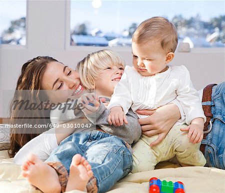 Mother and children cuddling and playing