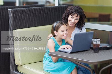 Mère et fille dans le café en utilisant portable ordinateur