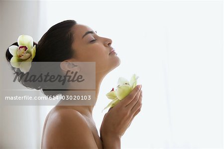 Young woman holding an orchid flower