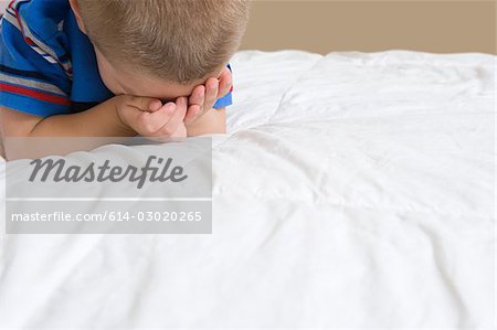 Petit garçon qui pleure sur lit