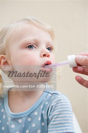 Little girl being given medicine