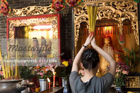 Une femme qui offre de l'encens dans un temple chinois, Macao