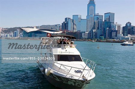 A pleasure launch at the Tsimshatsui pier with the Wanchai skyline in the background,Hong Kong