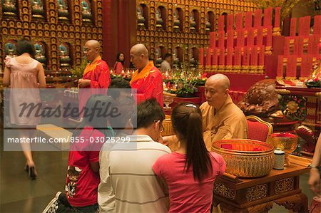 Monk giving blessing at Buddha Tooth Relic Temple and Museum,Chinatown,Singapore