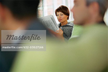 Businesswoman reading newspaper in waiting room
