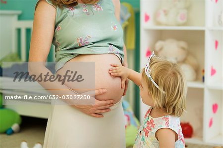 Toucher le ventre de femme enceinte de la mère de la fillette