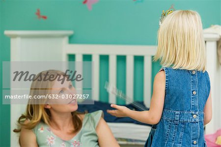 Kleine Mädchen spielen mit Mutter im Schlafzimmer