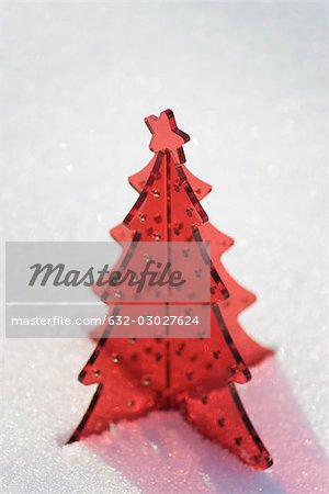 Red plastic Christmas tree decoration set in snow