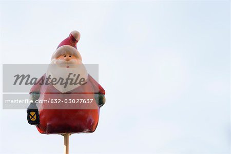 Santa Claus figurine on thin wooden post